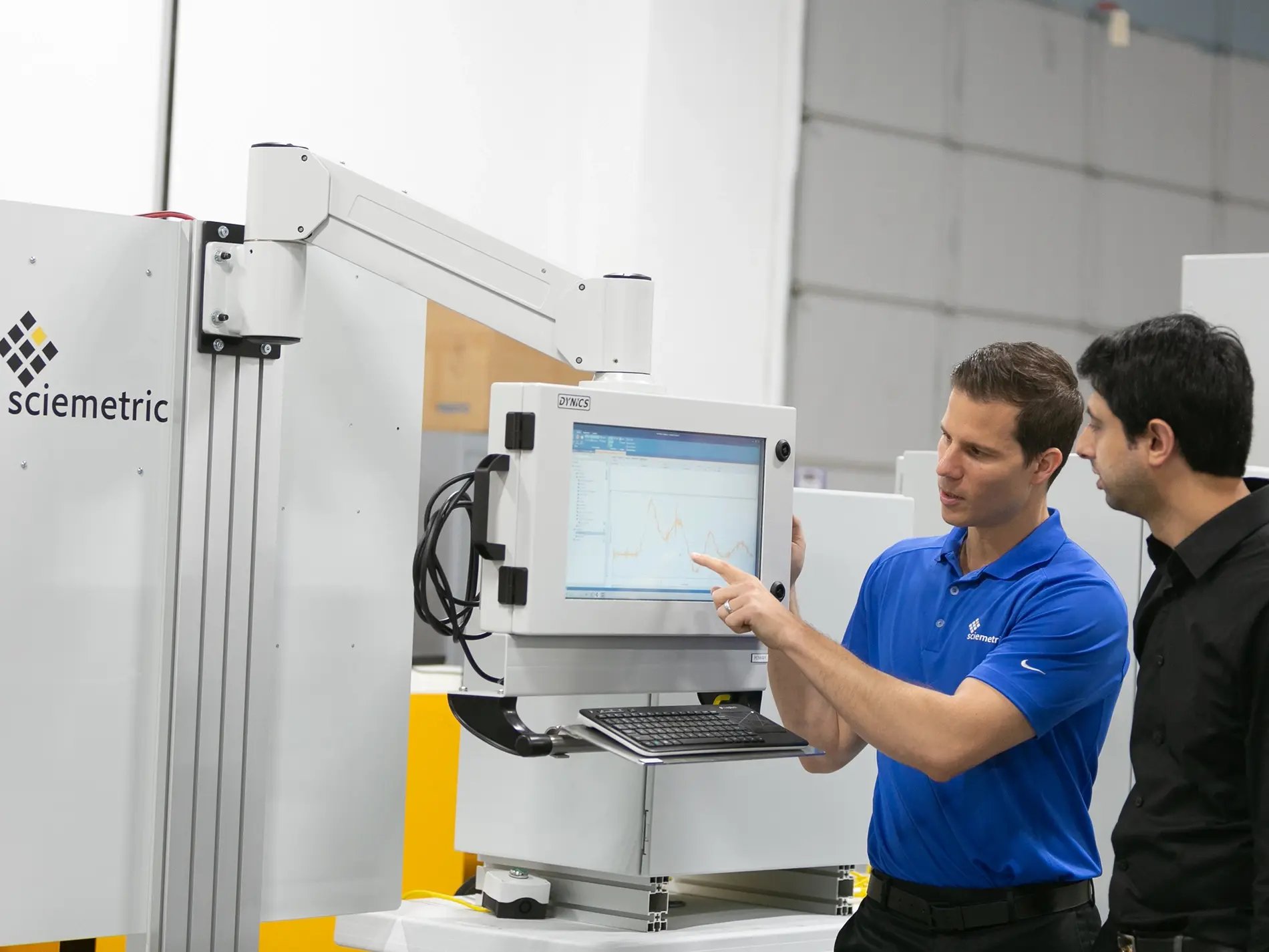 Two men looking at the monitor attached to a test machine