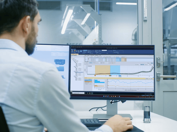 Bearded map looking at a computer monitor with reports and digital signatures on the screen
