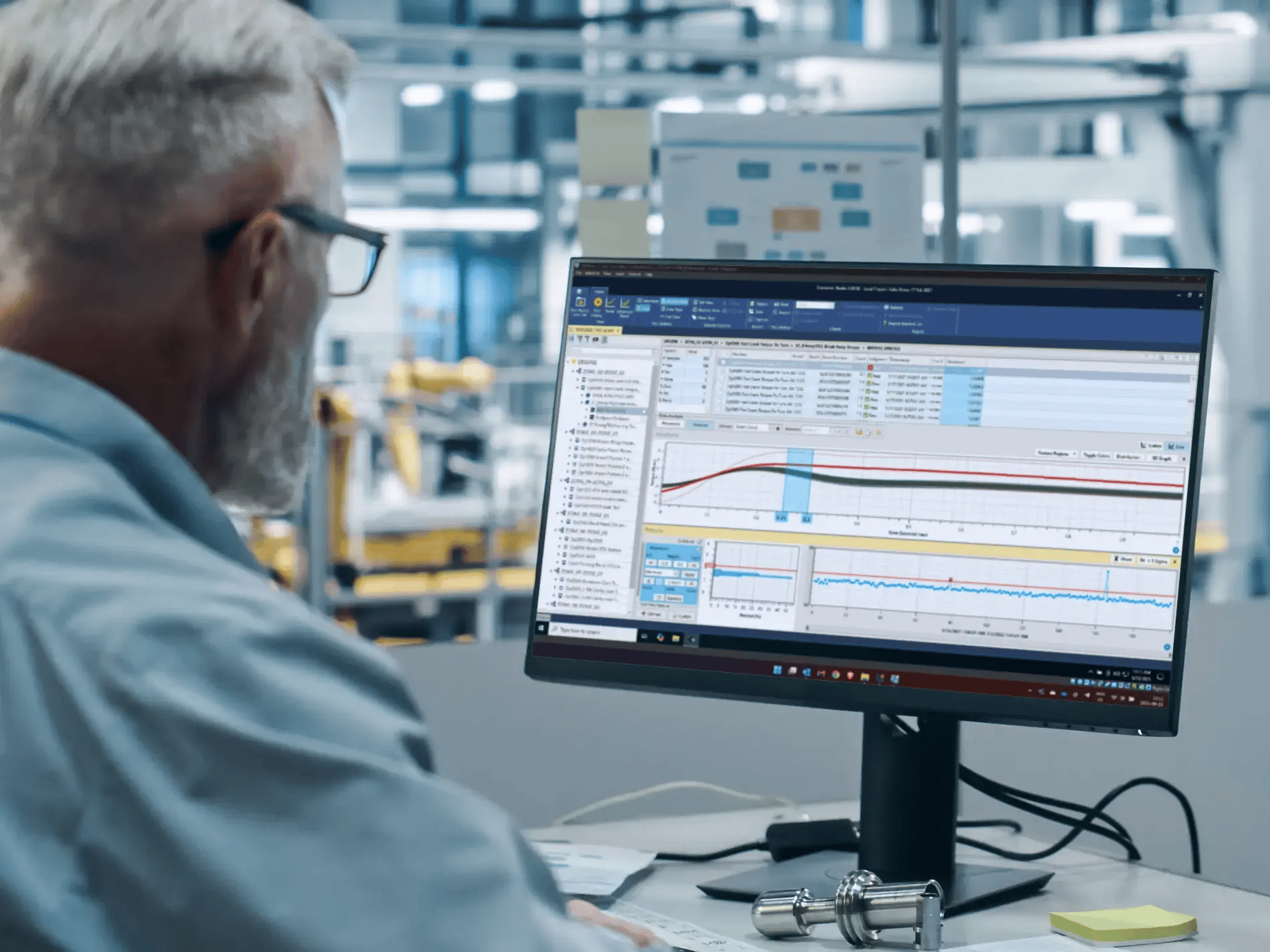 : Image of an older man looking at a monitor showing reports