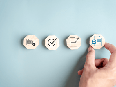 Hand with four blocks each featuring an icon showing a step in the quality process