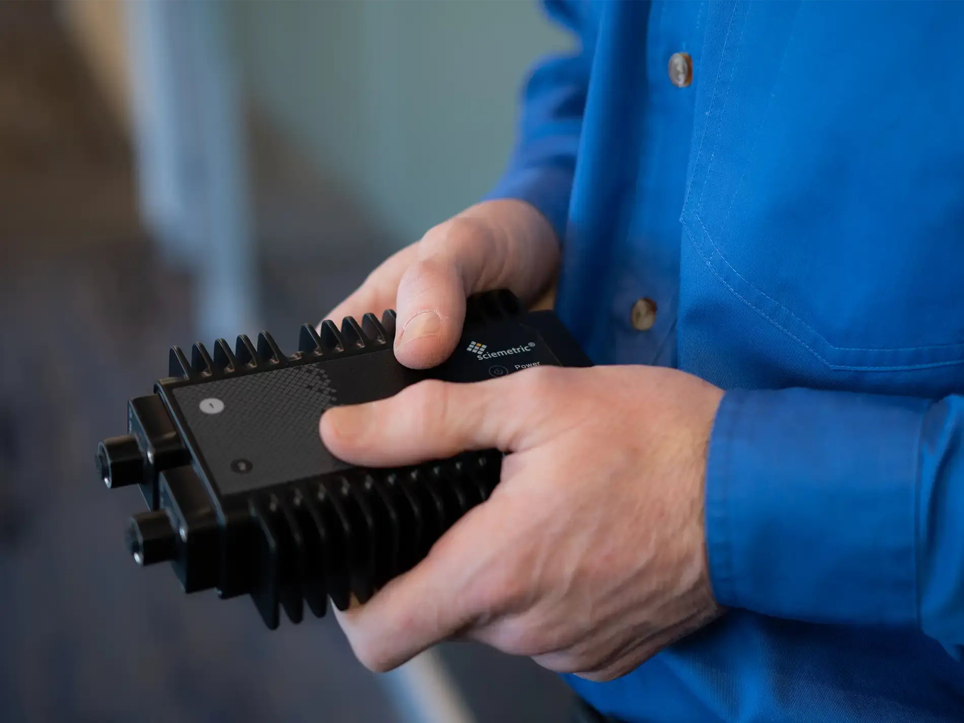 Two hands holding a small Sciemetric EDGE carrier