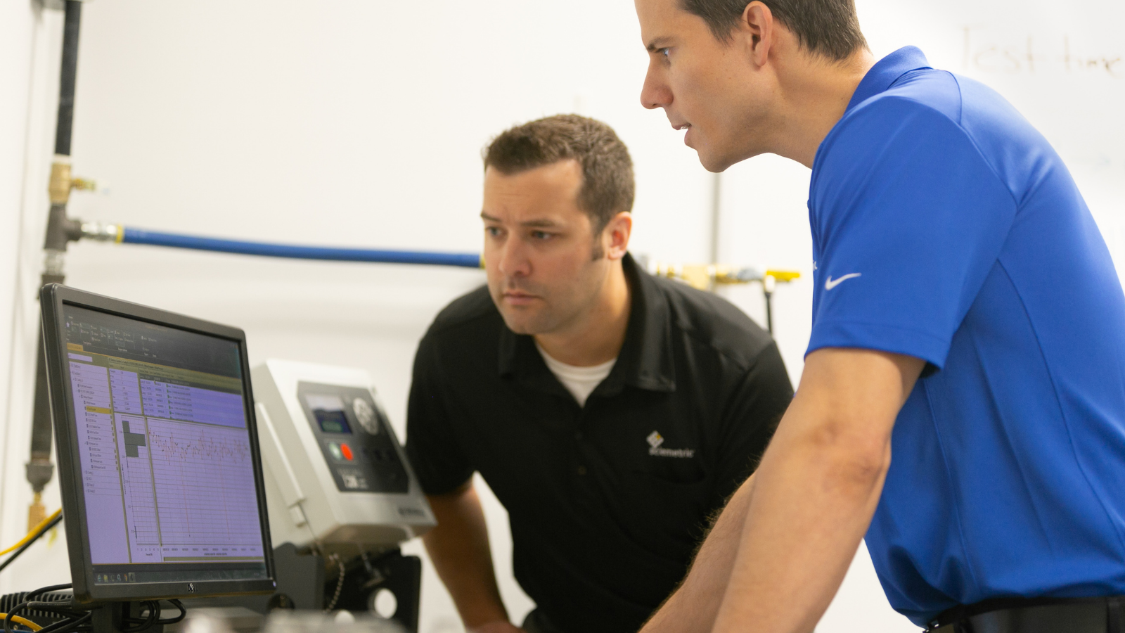 Engineers observing leak test data screen