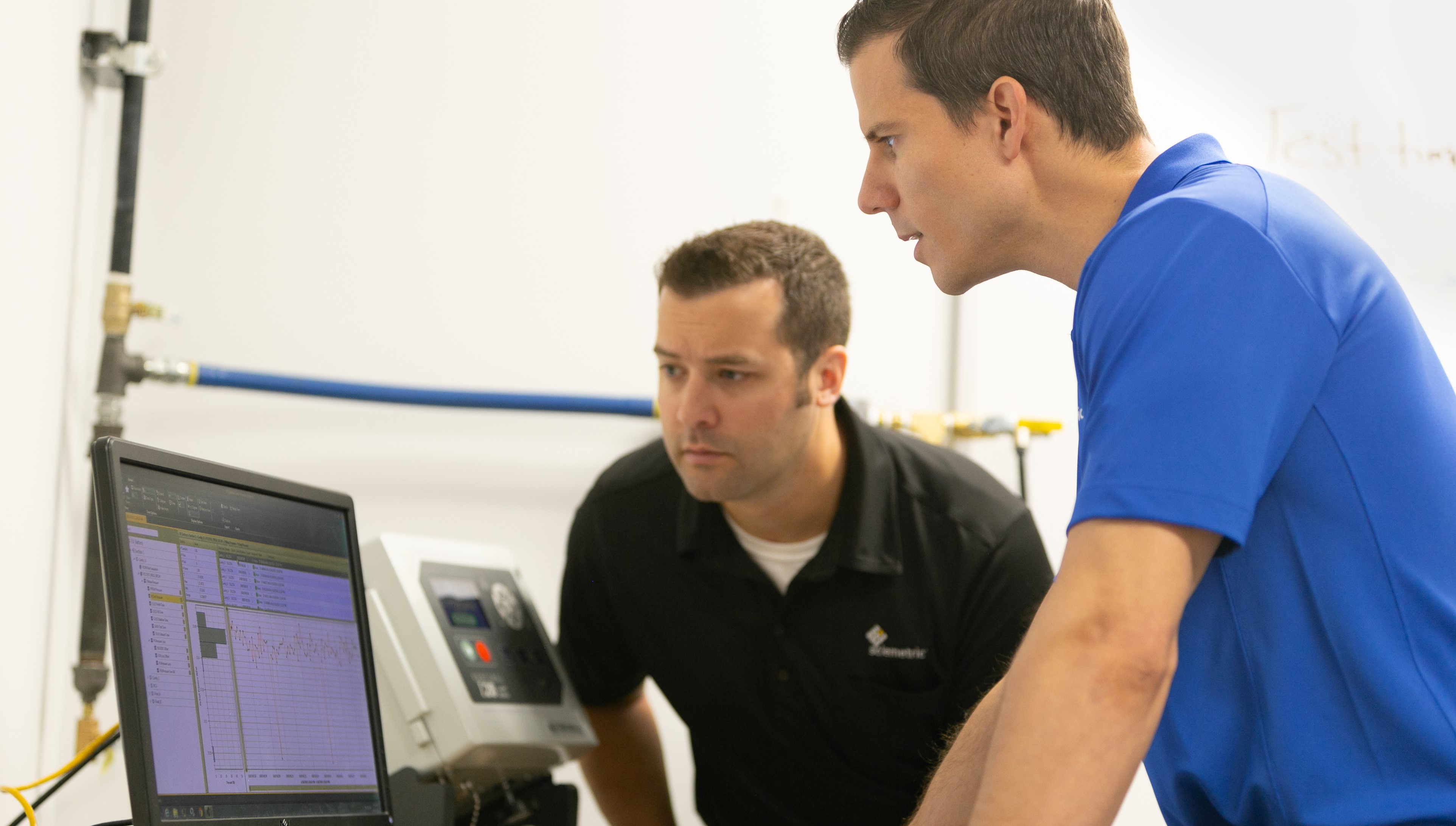 Two Sciemetric staff reviewing process data 