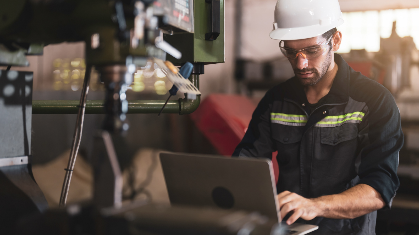 Man on production line using laptop